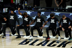 LAKE BUENA VISTA, FLORIDA - AUGUST 13: Lance Thomas of the Brooklyn Nets gestures as he and teammates kneel in honor of the Black Lives Matter movement prior to an NBA basketball game against the Portland Trail Blazers at AdventHealth Arena at ESPN Wide World Of Sports Complex on August 13, 2020 in Lake Buena Vista, Florida. NOTE TO USER: User expressly acknowledges and agrees that, by downloading and or using this photograph, User is consenting to the terms and conditions of the Getty Images License Agreement. (Photo by Ashley Landis-Pool/Getty Images)